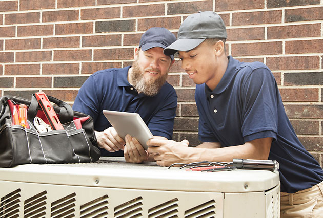 Two men working on an AC using tablet with Business Manager 365 Two men working on an AC using tablet with Business Manager 365